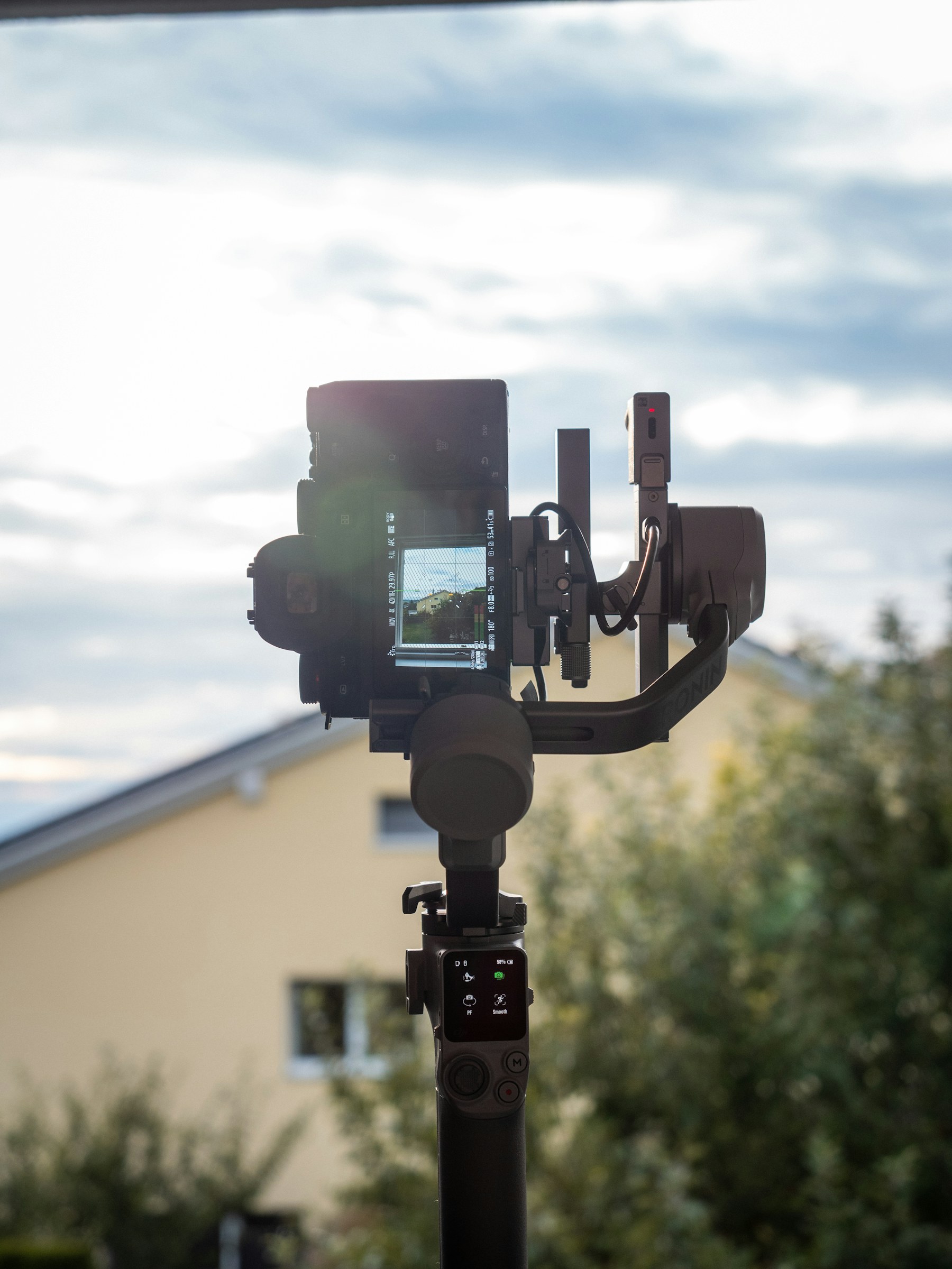 Professionelle Kamera auf einem Gimbal vor einem Wohnhaus